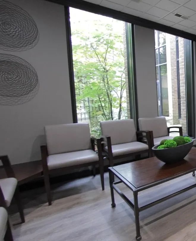 The waiting room seating and its tall garden windows.